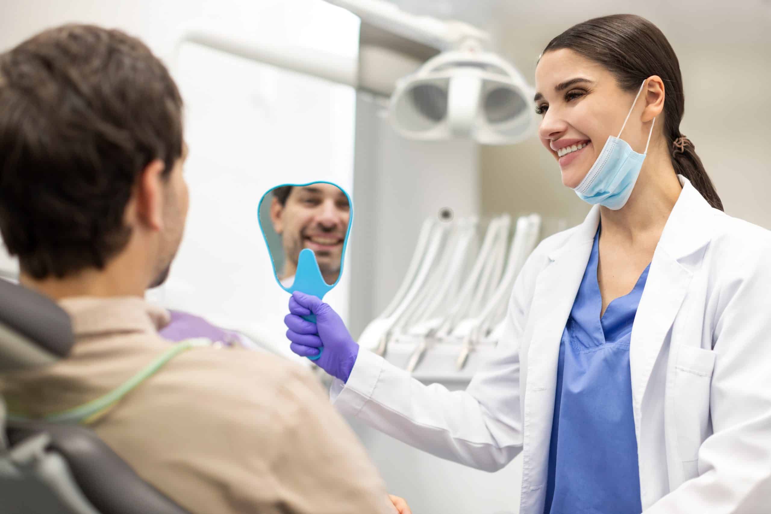 Positive man checking results of teeth whitening treatment at a dentist in Cypress.